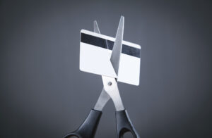 Tijeras cortando una tarjeta de crédito - Falta de transparencia en tarjetas de crédito revolving